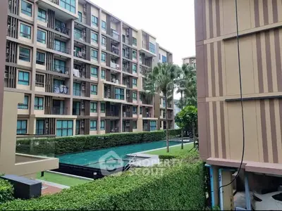 Modern apartment complex with pool and lush greenery, offering a serene urban living experience.
