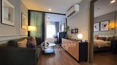 Modern living room with stylish decor and cozy bedroom in open layout apartment.