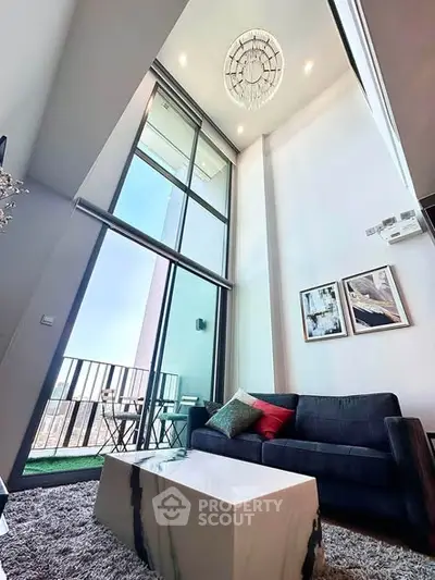 Stunning high-ceiling living room with modern decor and balcony view