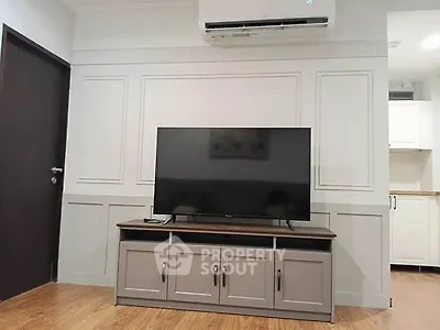 Modern living room with sleek TV setup and air conditioning unit, perfect for cozy entertainment.