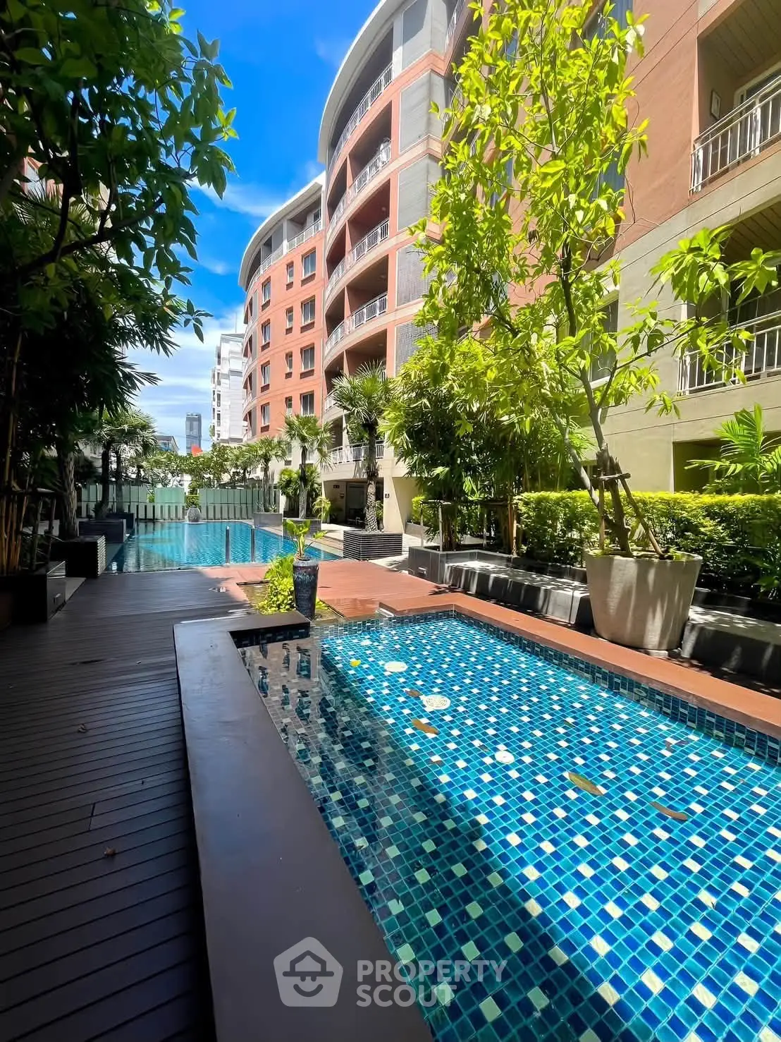 Luxurious condominium with stunning pool and lush greenery, perfect for relaxation and leisure.