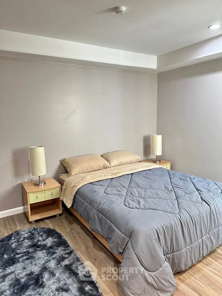 Cozy bedroom with modern decor and plush bedding in a stylish apartment.