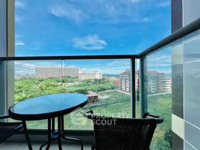 Stunning balcony view with modern glass railing overlooking lush greenery and cityscape.