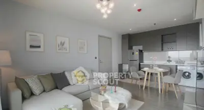 Modern living room with open kitchen, stylish decor, and cozy seating area.