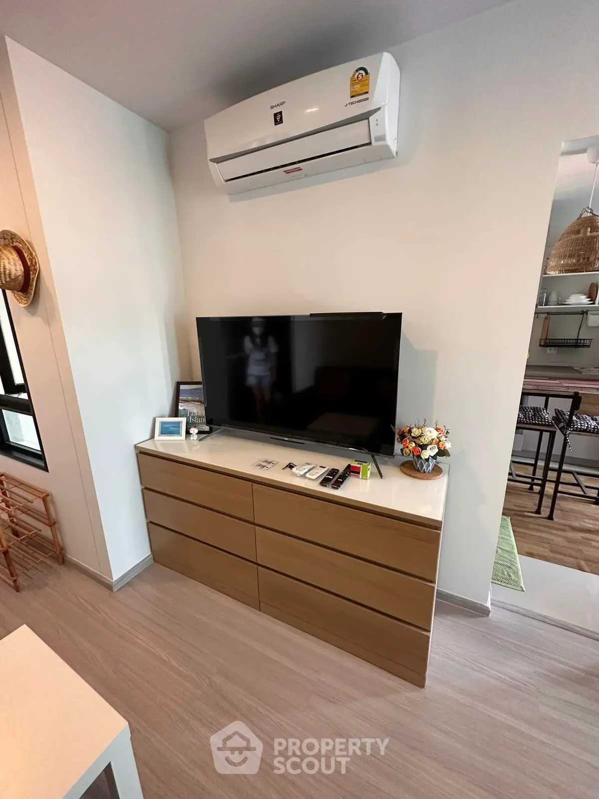 Modern living room with sleek TV setup and air conditioning in stylish apartment.