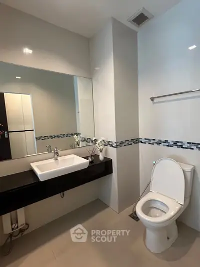 Modern bathroom with sleek design and large mirror in a contemporary home.