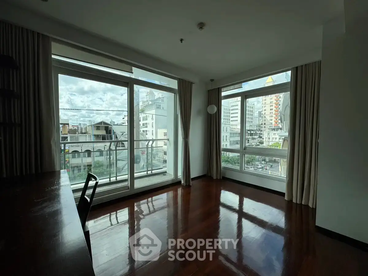 Spacious corner unit with large windows offering a stunning city view, perfect for a modern living room setup.