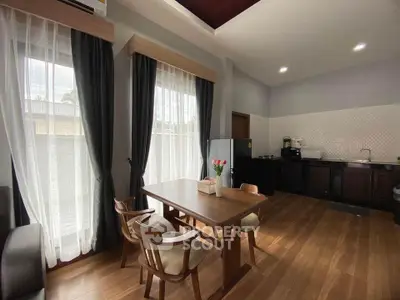 Spacious kitchen with dining area, featuring modern appliances and elegant wooden flooring, ideal for family gatherings.