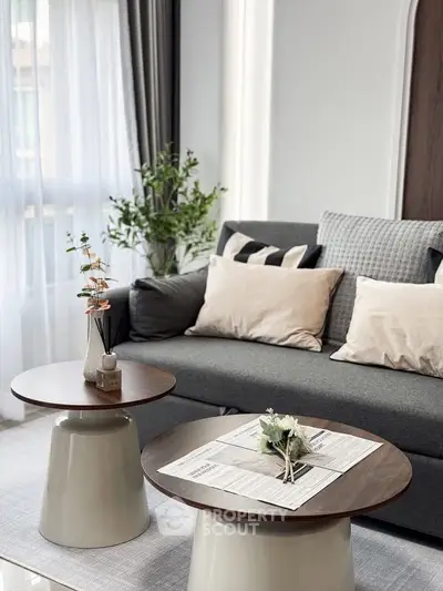 Modern living room with stylish gray sofa and chic coffee tables, perfect for cozy gatherings.
