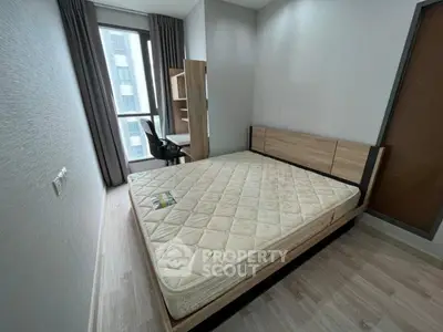 Modern bedroom with large window and study desk in urban apartment