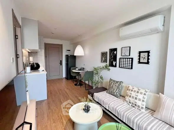 Modern living room with stylish decor and open kitchen layout, featuring contemporary furniture and wall art.