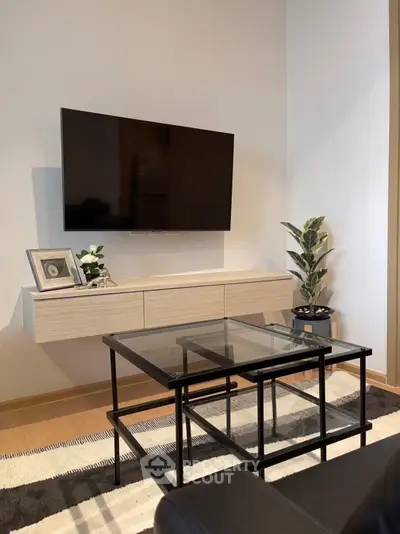 Modern living room with sleek TV setup and stylish glass coffee table