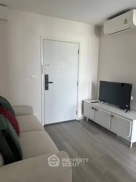 Cozy living room with modern decor, featuring a sleek TV unit and comfortable sofa.