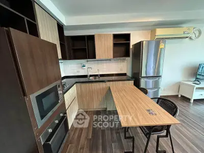 Modern kitchen with sleek appliances and wooden cabinetry in a stylish apartment.