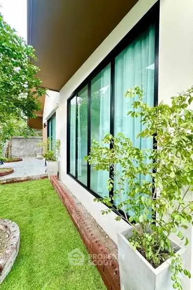 Charming garden view with modern glass windows and lush greenery