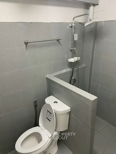 Modern bathroom with sleek gray tiles and compact shower area