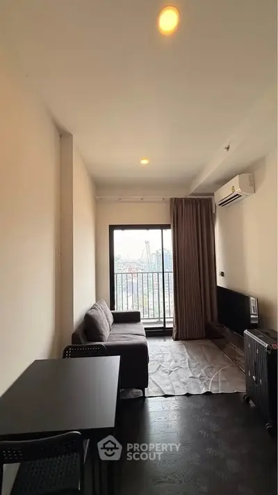 Modern living room with city view, featuring sleek furniture and air conditioning.