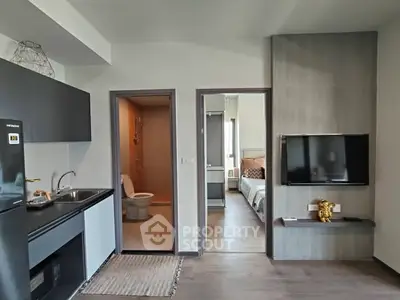 Modern apartment interior with open kitchen and cozy living area, featuring sleek design and contemporary furnishings.