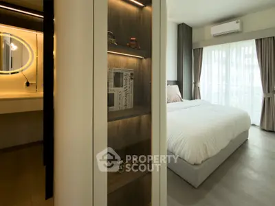 Modern bedroom with stylish decor and ample natural light, featuring a cozy bed and elegant shelving.