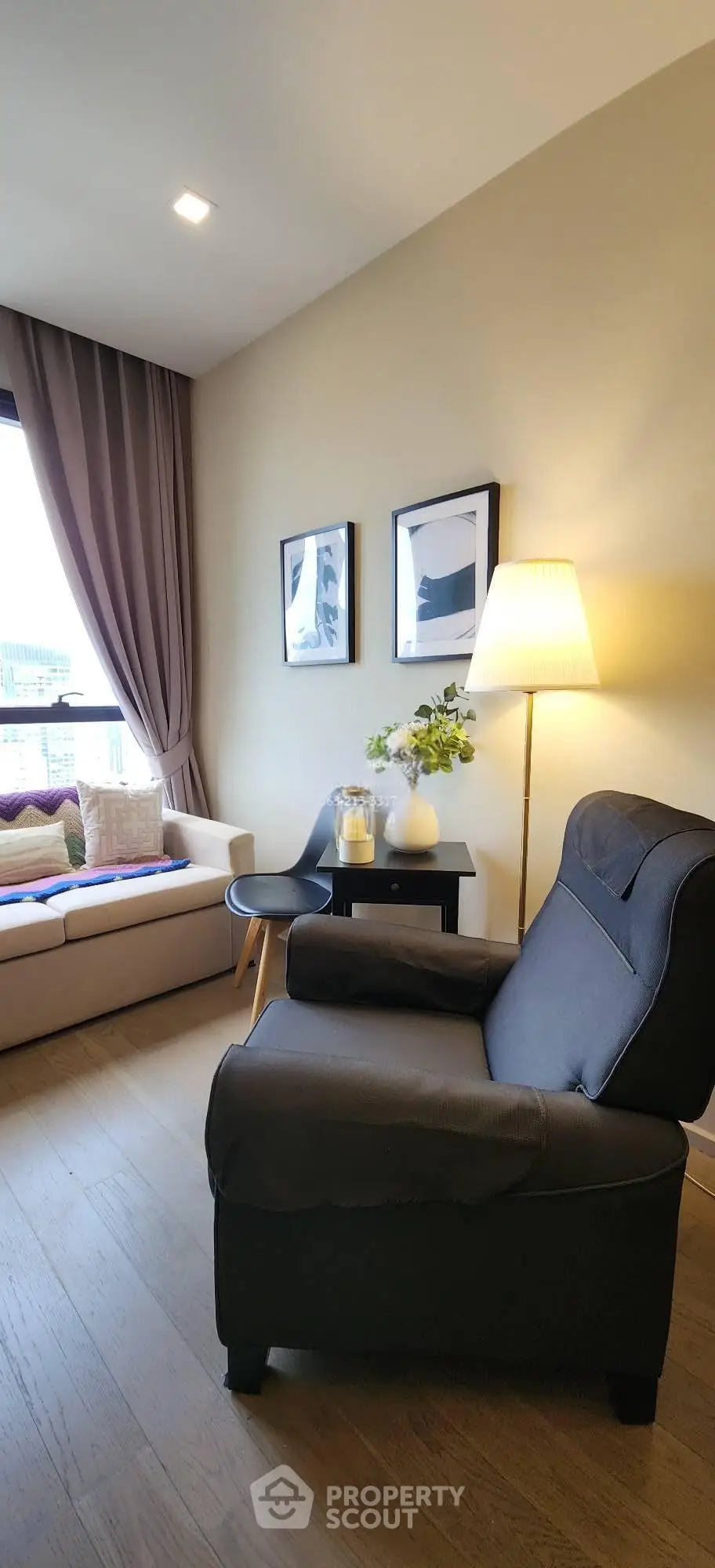 Cozy living room with armchair, sofa, and elegant decor in modern apartment.