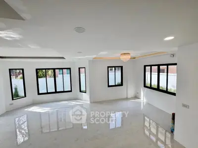 Spacious modern living room with large windows and elegant chandelier