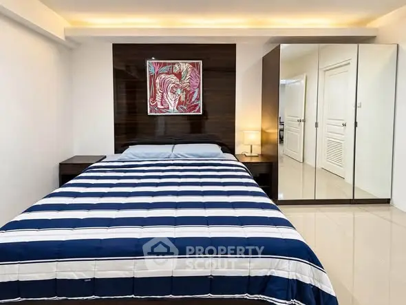Modern bedroom with stylish decor and mirrored wardrobe