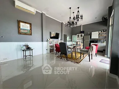 Chic living room with elegant chandelier and modern kitchen setup.