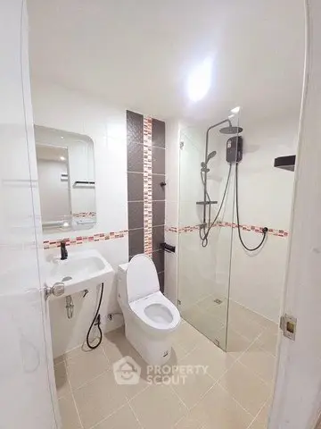 Modern bathroom with glass shower and sleek fixtures in a contemporary home.
