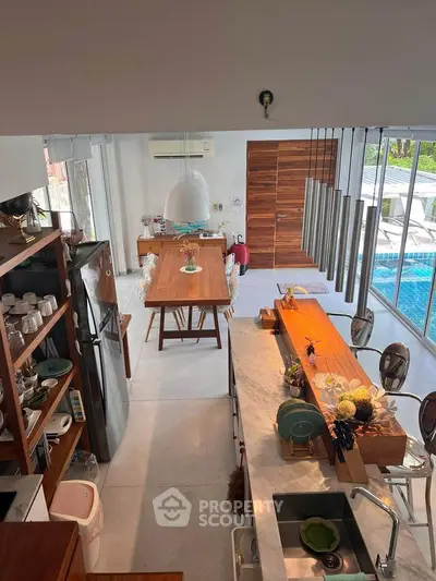 Stunning open-plan kitchen and dining area with pool view and modern decor