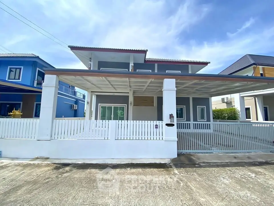 Modern two-story house with spacious carport and stylish facade in a suburban neighborhood.