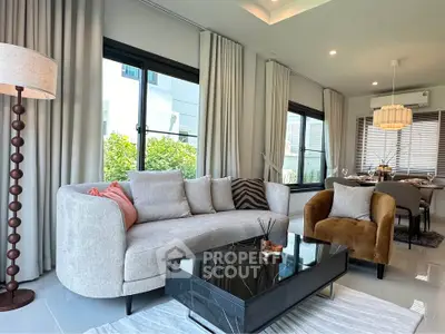 Modern living room with elegant decor, featuring a plush sofa, stylish armchair, and sleek black coffee table.