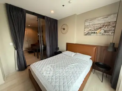 Modern bedroom with stylish decor and large window offering natural light