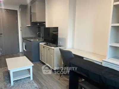 Modern studio apartment with integrated living space featuring a sleek kitchenette, cozy dining area, and ample shelving, perfect for urban living.