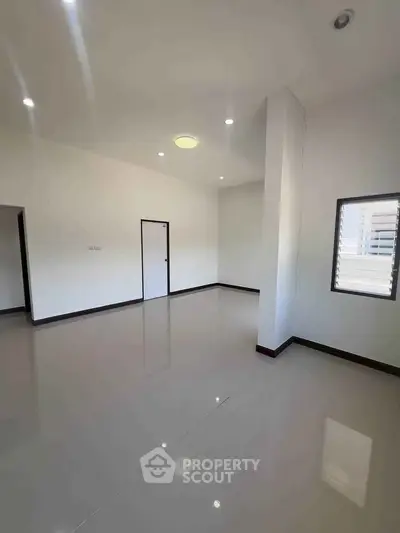 Spacious empty room with glossy tiled floor and bright lighting, perfect for customization.