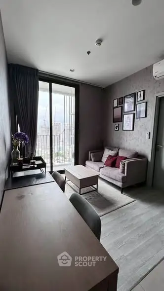 Modern living room with large window and stylish decor in a high-rise apartment.