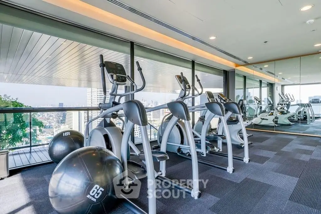 Modern gym with city view and exercise equipment in luxury building.