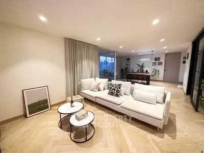 Spacious modern living room with elegant decor and open layout, featuring stylish furniture and ambient lighting.