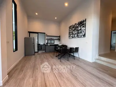 Modern open-plan kitchen and dining area with sleek design and wooden flooring