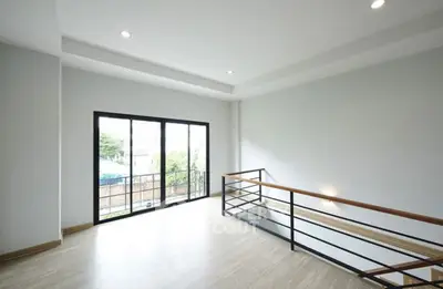 Spacious modern interior with large windows and sleek railing, perfect for natural light lovers.