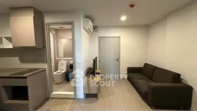 Modern apartment interior with cozy living room and open kitchen layout.