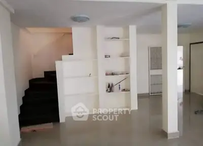 Spacious interior with built-in shelves and staircase, ideal for modern living.