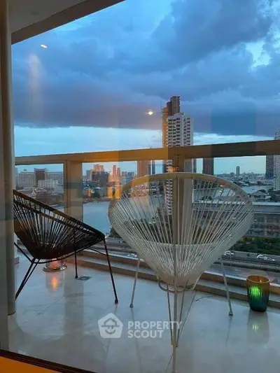 Stunning balcony view with modern chairs overlooking city skyline at dusk.