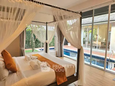 Luxurious bedroom with pool view and elegant canopy bed, perfect for a serene retreat.