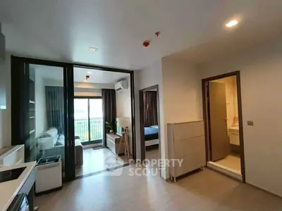 Modern apartment interior with open layout, featuring a cozy living room, kitchen, and bedroom with balcony access.