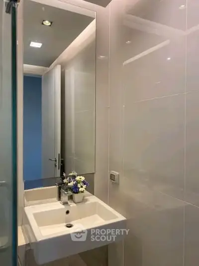 Modern bathroom with sleek sink and mirror in a stylish real estate property.
