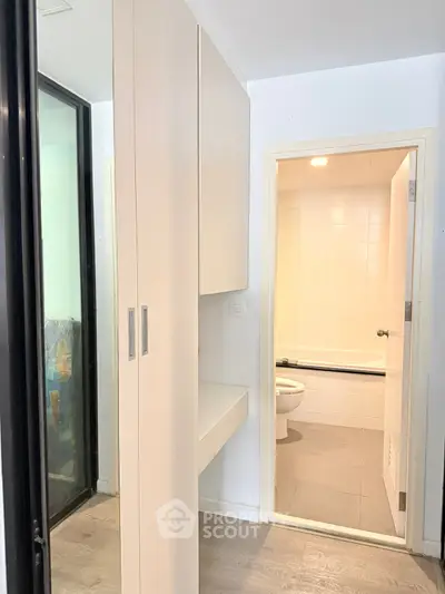 Modern apartment interior with sleek bathroom and built-in storage, featuring contemporary design and efficient use of space.