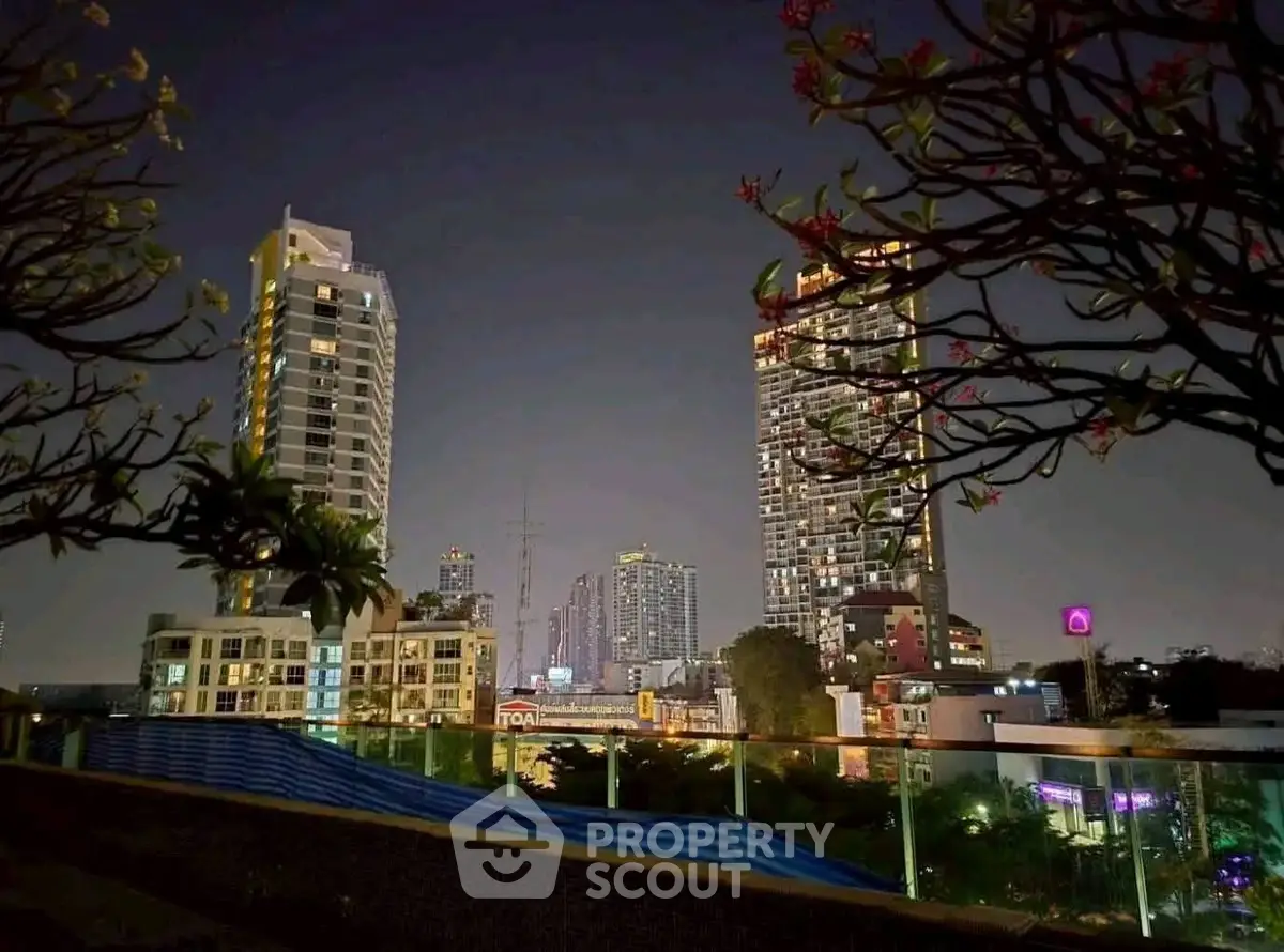 Stunning night view of city skyline with modern high-rise buildings and lush greenery.