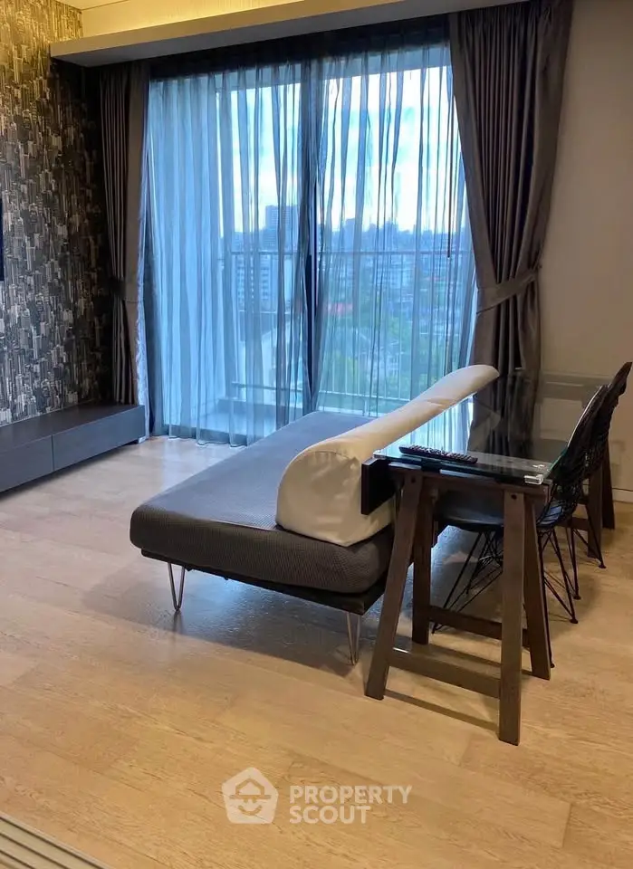 Stylish modern living room with floor-to-ceiling windows and chic decor in urban apartment.