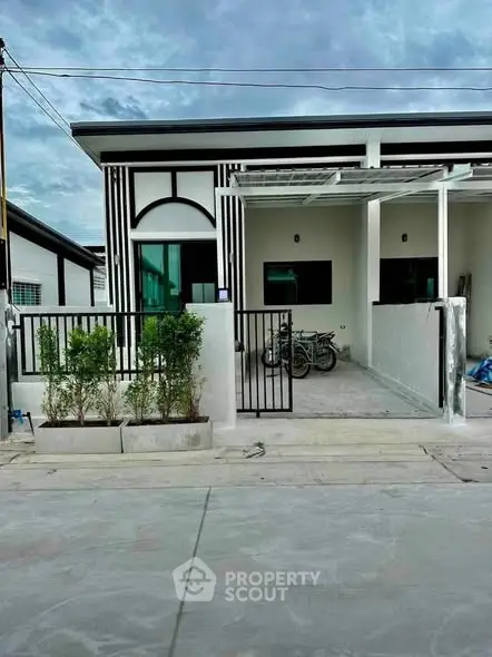 Modern single-story house with sleek facade and gated driveway