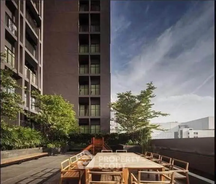 Stunning rooftop terrace with modern outdoor furniture and lush greenery in a high-rise building.